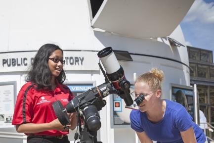 Two girls using telescope