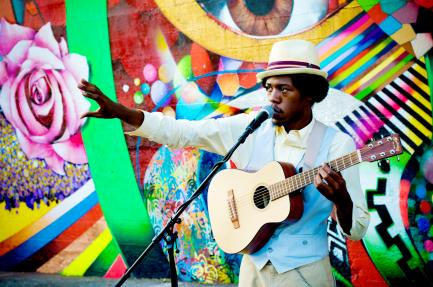 Musician in front of colorful mural