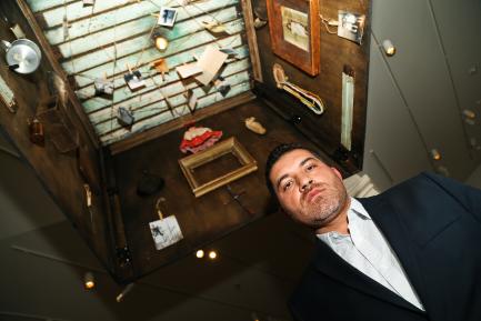 Artist standing beneath his installation