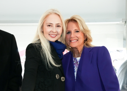 Two women pose together and smile directly ahead