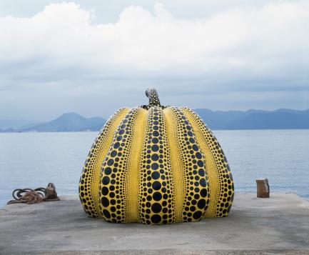 Sculpture of giant pumpkin sitting on pier