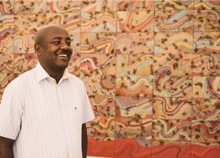 Artist poses with one of his artworks