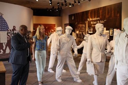 Man and woman with white sculptures of people in natural poses