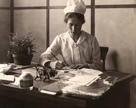 Nurse writes at desk
