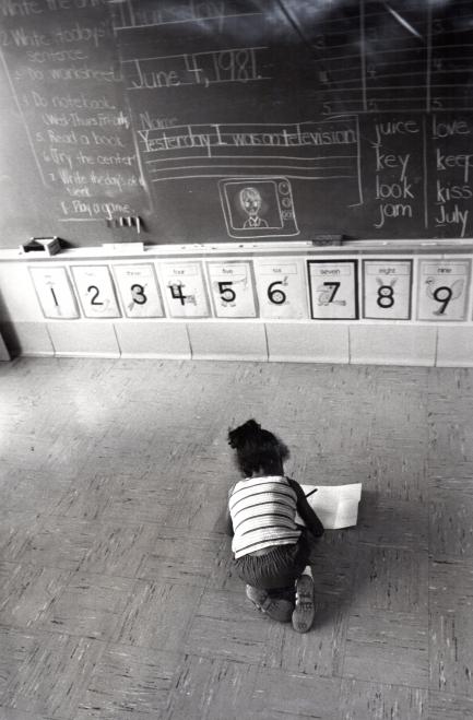 Child alone in classroom reading