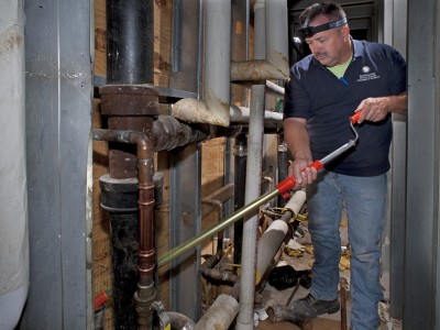 Image of a man with a device in his hand performing an equipment inspection