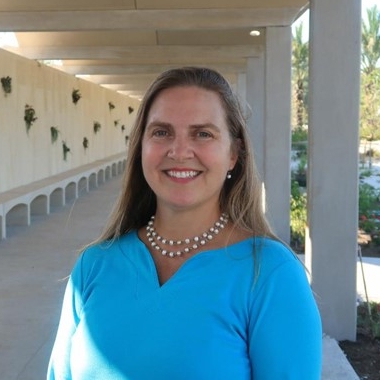 Woman smiles while standing outside
